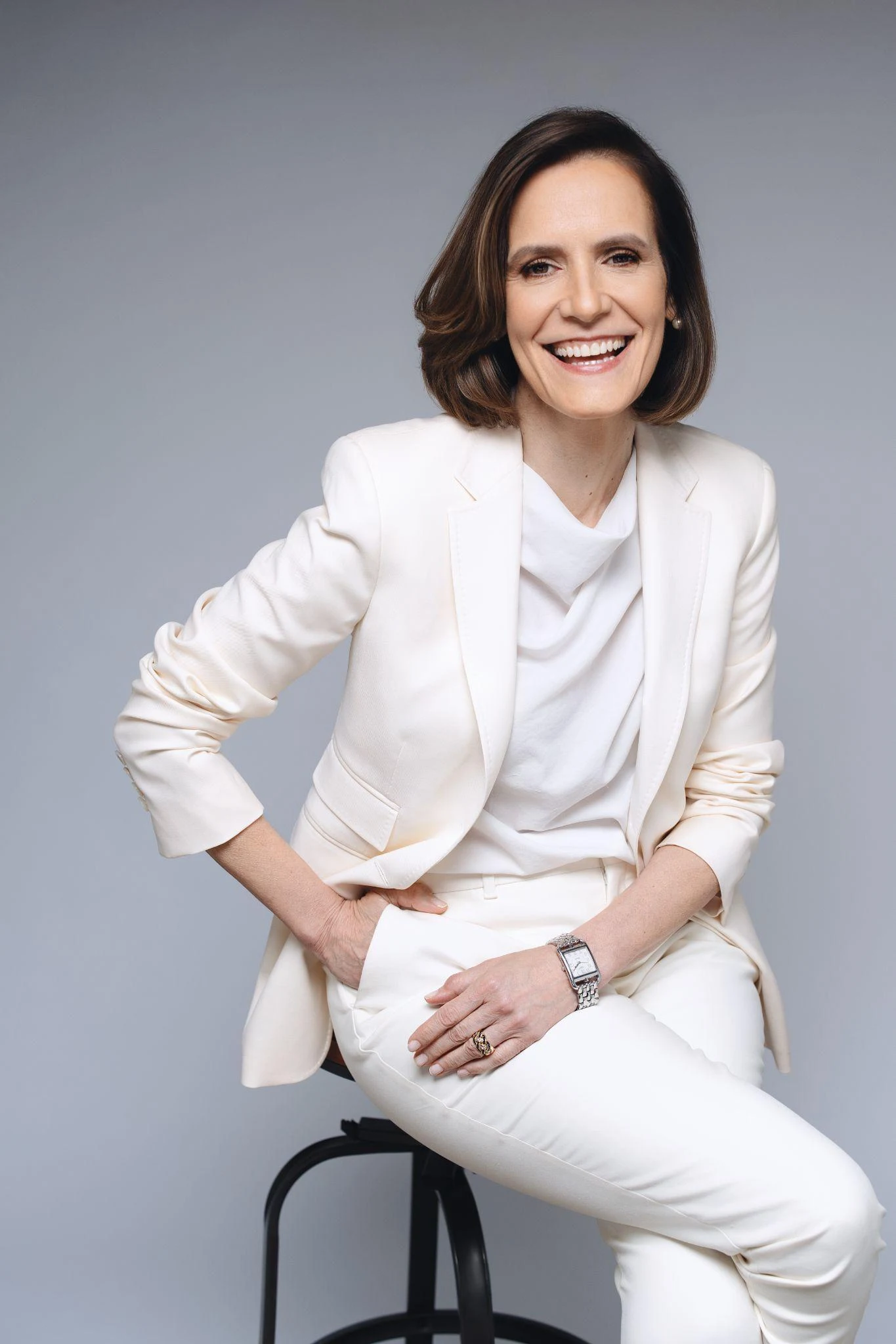 Gabriela Pulido seated in a white suit